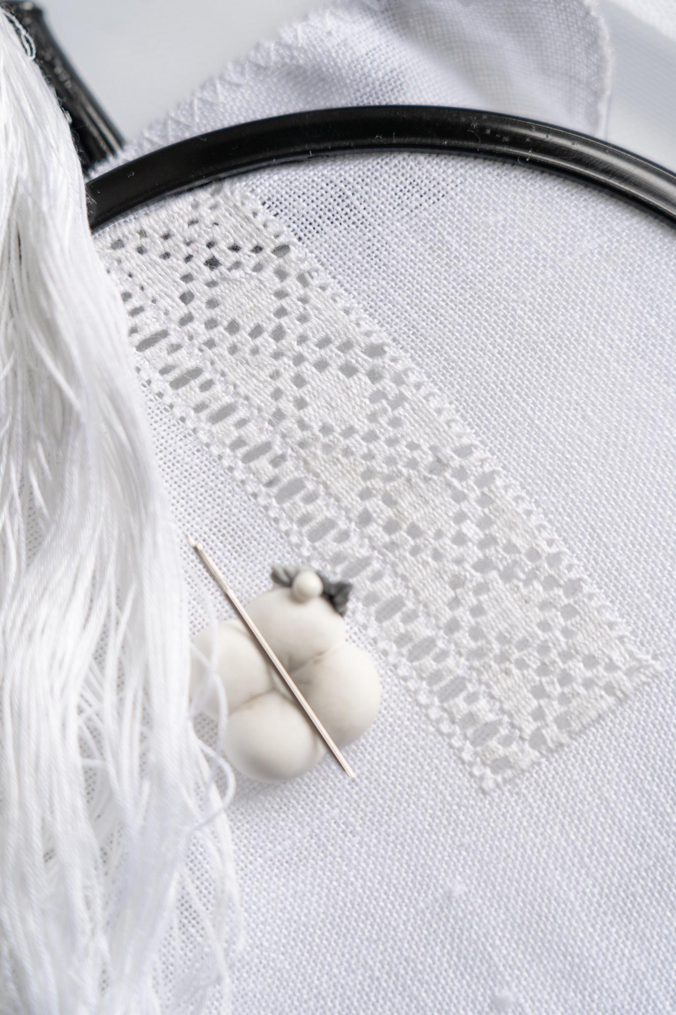 Dettaglio: punto broderie su stoffa chiara